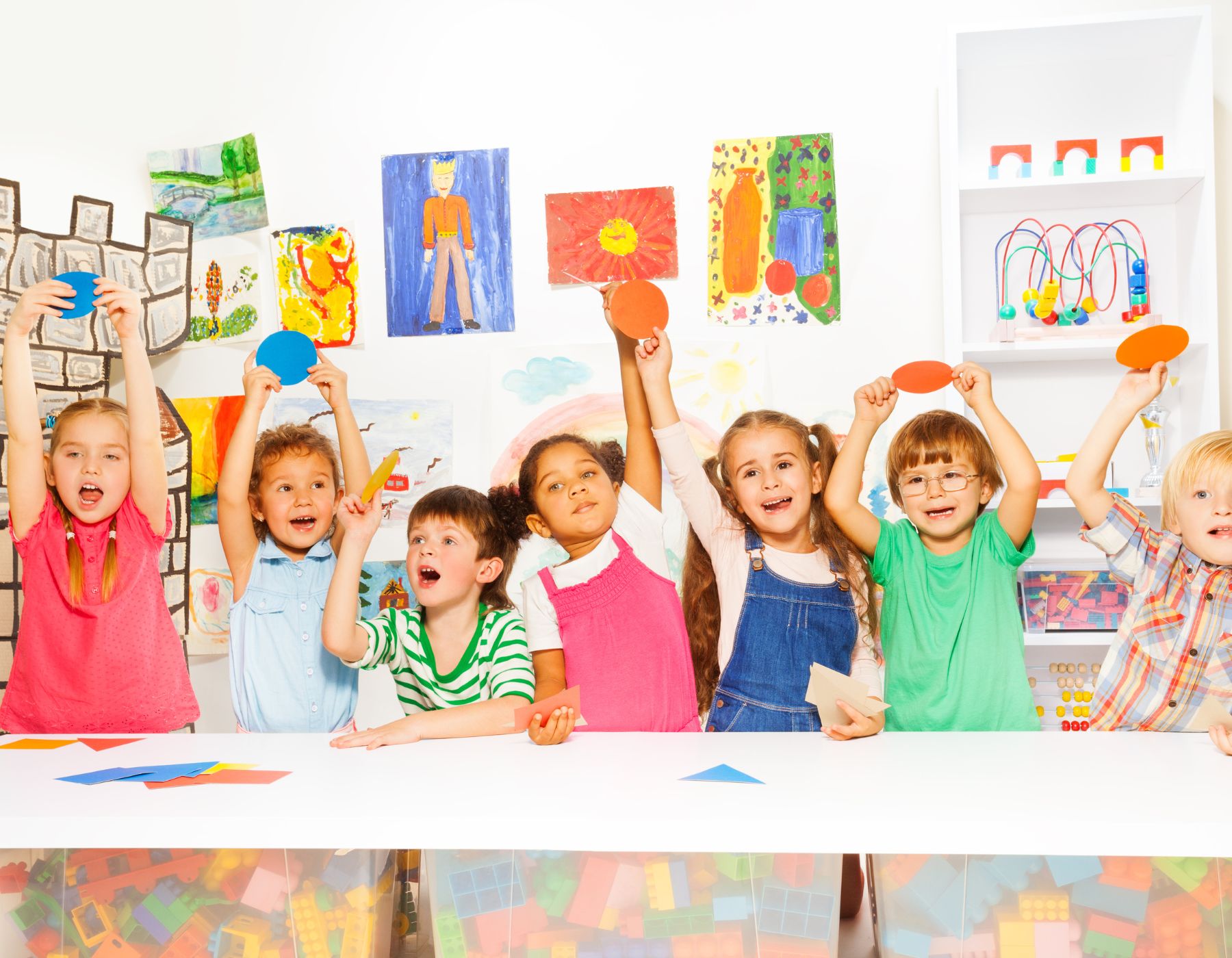 Alumnos de kínder y primaria sosteniendo figuras geométricas de colores durante un taller de lógica matemática en el curso de verano del Instituto Víctor Hugo en la Narvarte.